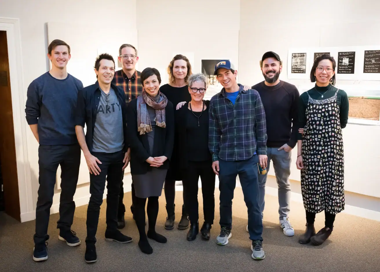 A group of nine adults standing in an art gallery