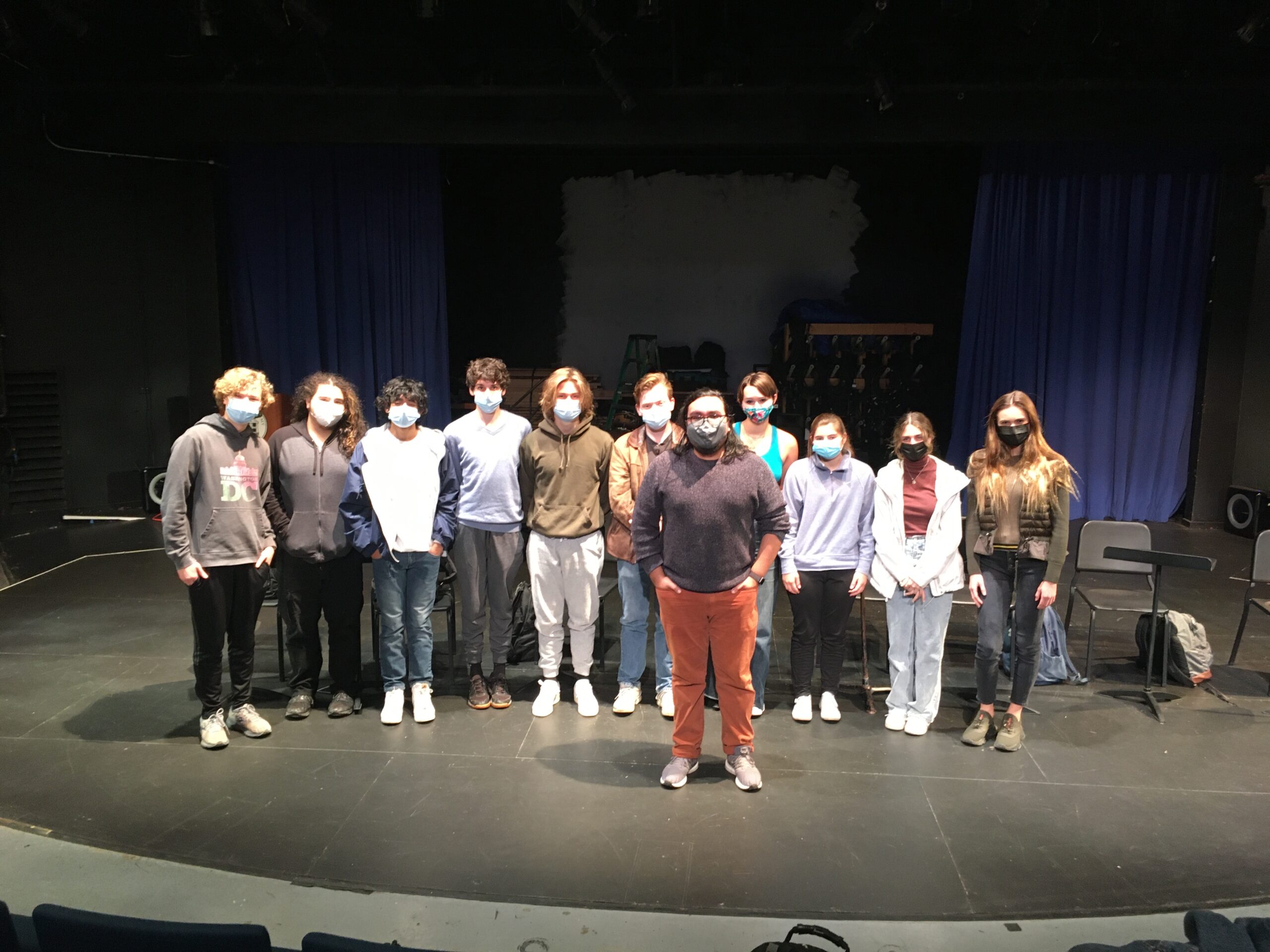 Students pose with guest playwright on stage in the P.A.C.