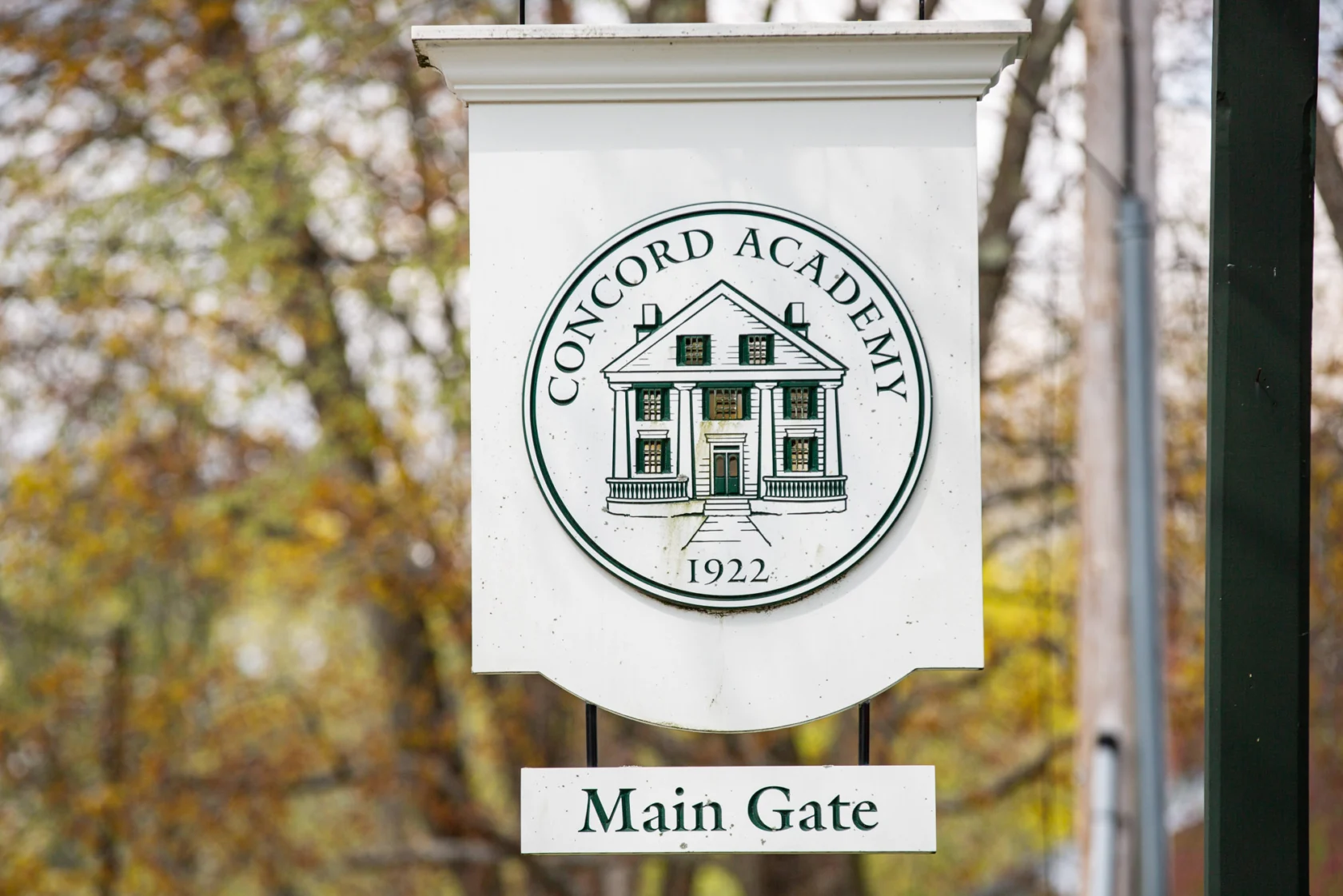 Sign for Concord Academy's main gate, featuring the school's emblem, which includes a building illustration and the founding year, 1922.