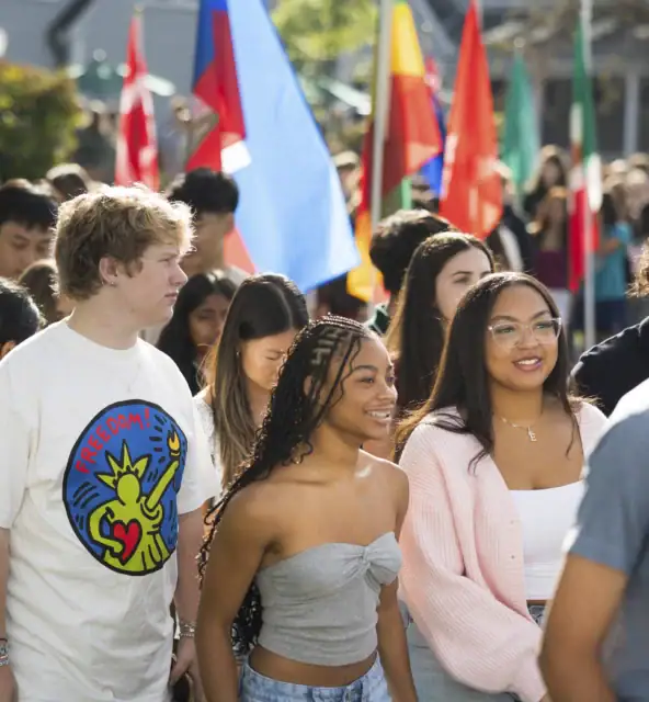 Students walk holding flags of their representative countries.