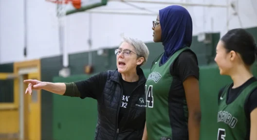 Girls basketball coach advises student on game play.